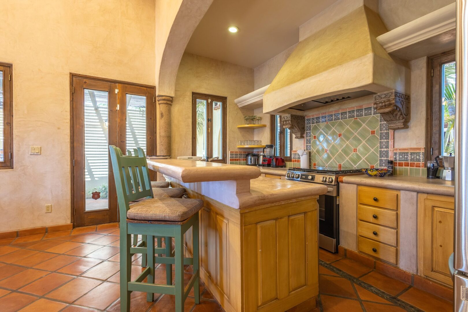 Kitchen island with bar seating and arched entryway