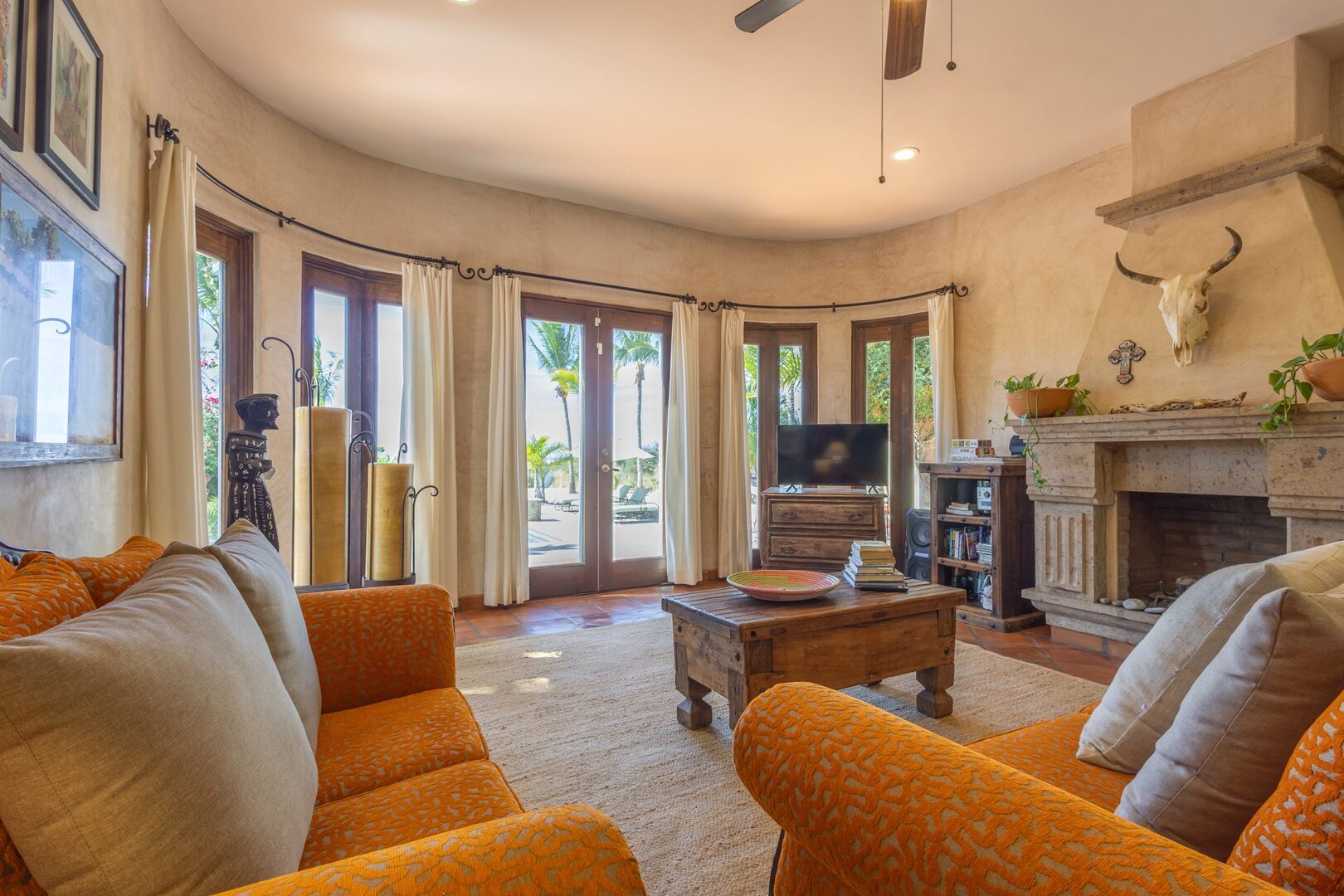 Living room with citrus-toned seating and stone fireplace